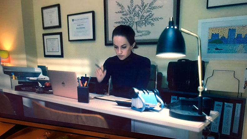 Theodora Crain at her desk with WJC on wall