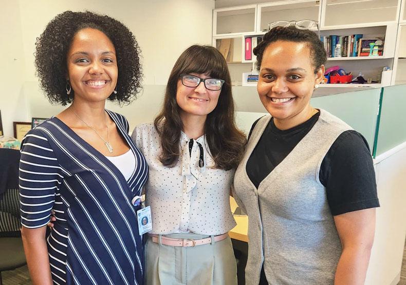 Three women posing for camera in office environment