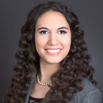 photo of woman with long, dark, curly hair smiling