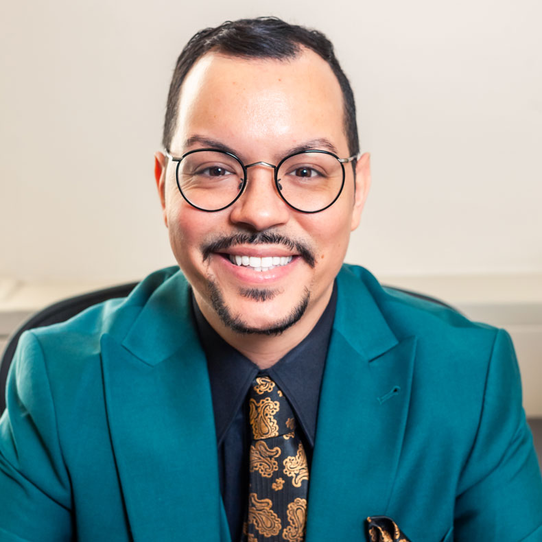 Profile photo of Dr. Juan Rosario, wearing glasses and a teal blue jacket