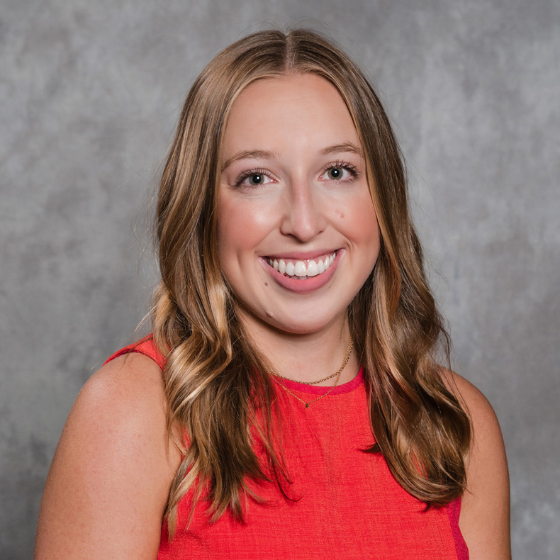 Profile photo of Anna Uston smiling in red top and neutral background