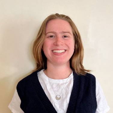 Photo of woman smiling with light brown hair with a neutral background