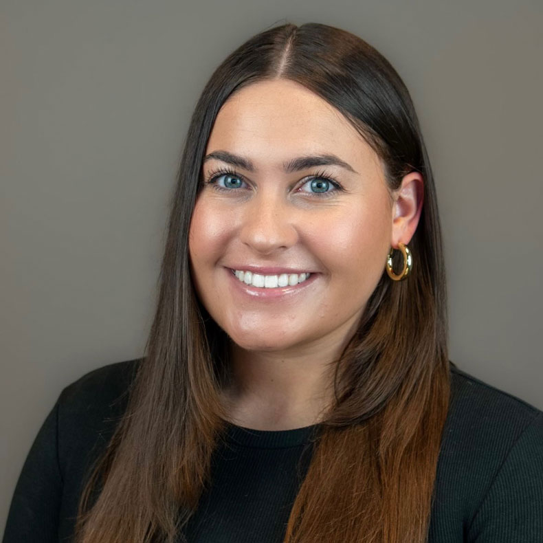 Portrait photo of Leah Huling, smiling, with gray background