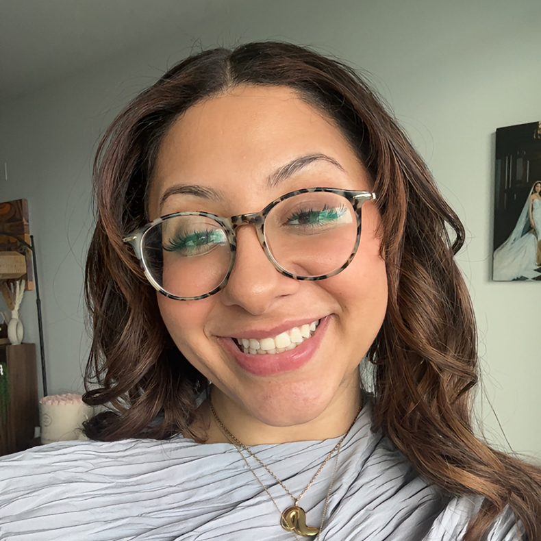 Close up portrait photo of Marina wearing glasses and a gray top