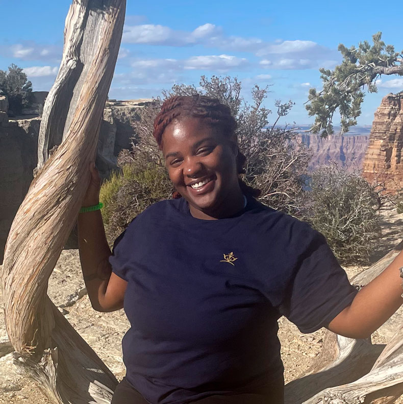 Photo of woman smiling in blue shirt with a canyon in the background