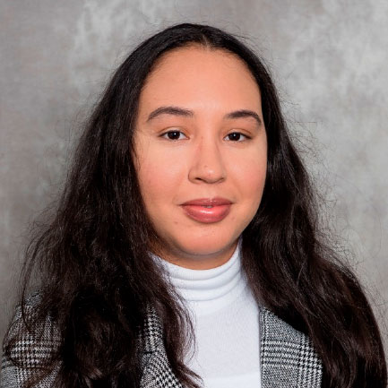 Photo of woman smiling with long brown hair with a neutral background