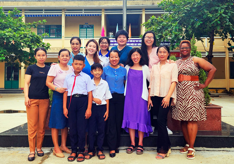 diverse group posing in front of building in Vietnam