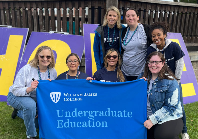 group of students in front of college banner