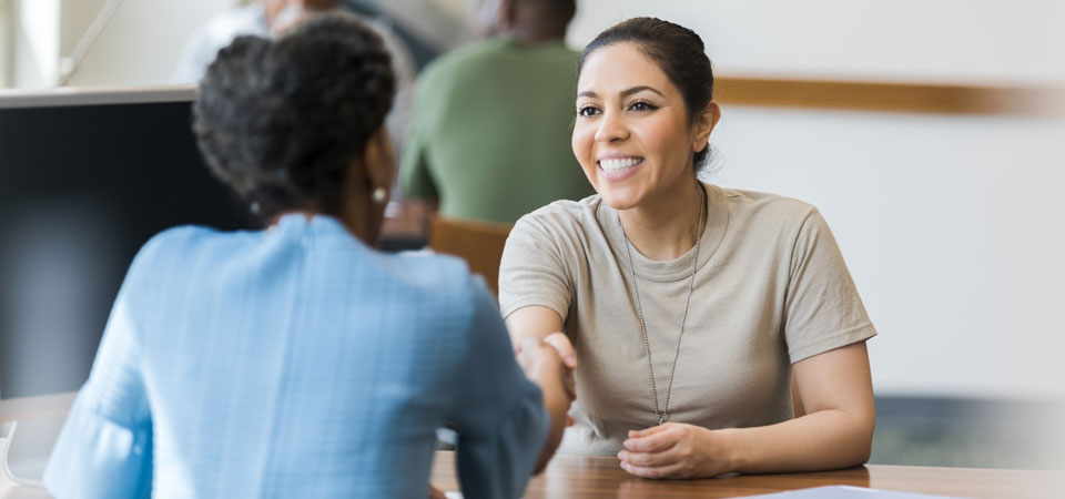 Woman shaking hands over desk