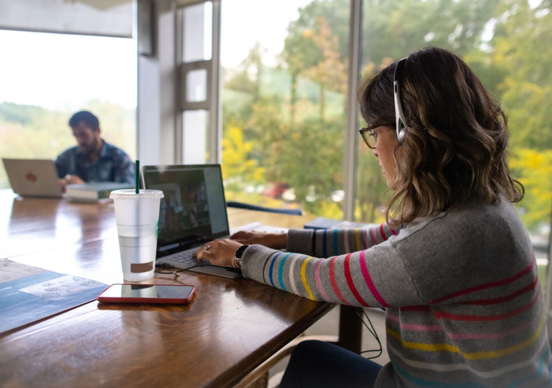 Student taking course online in library