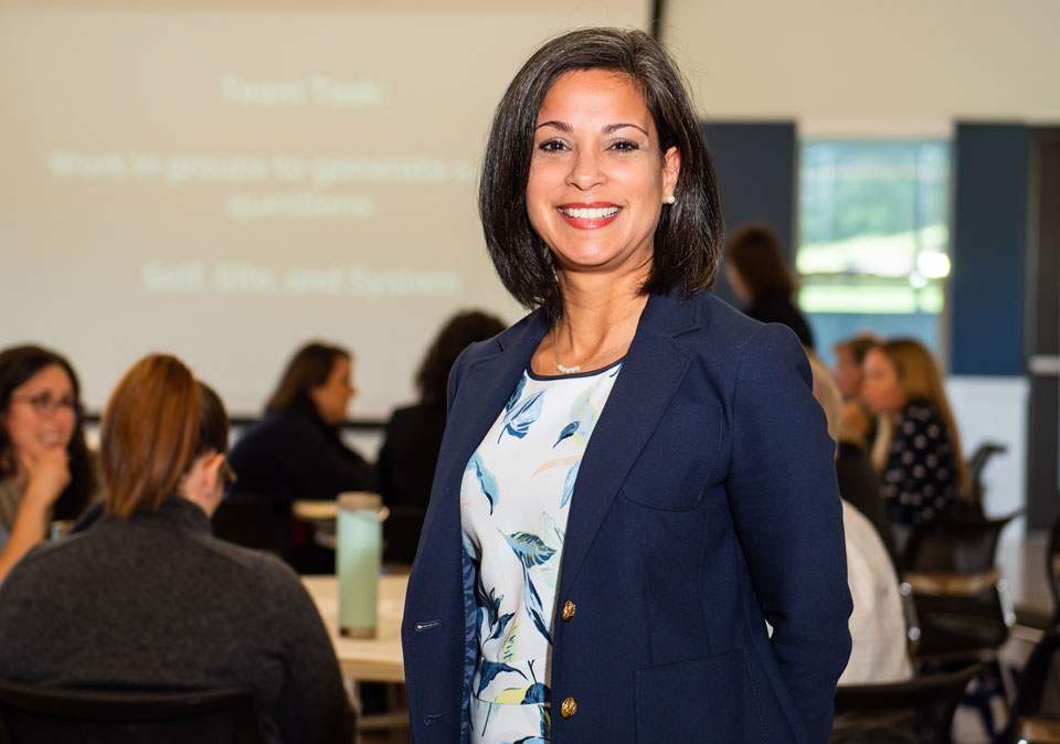 image of woman smiling in back of classroom