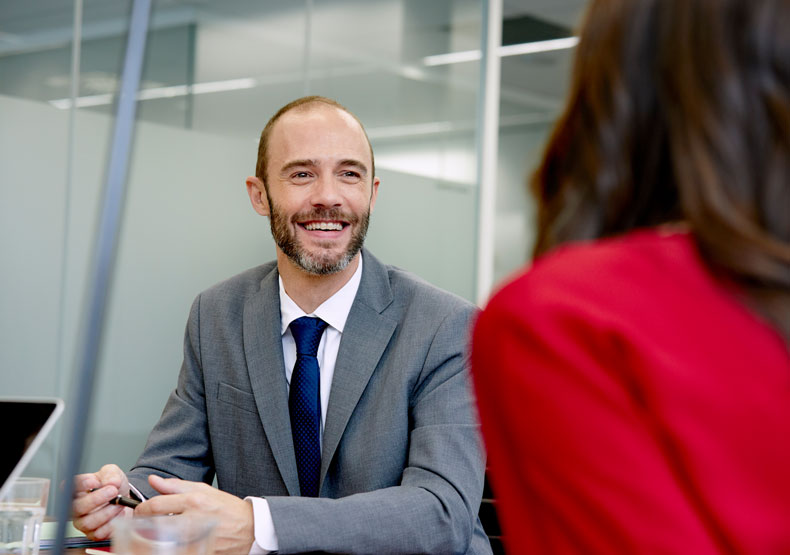 male talking with someone across table