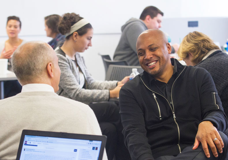 Photo of men talking and smiling in classroom