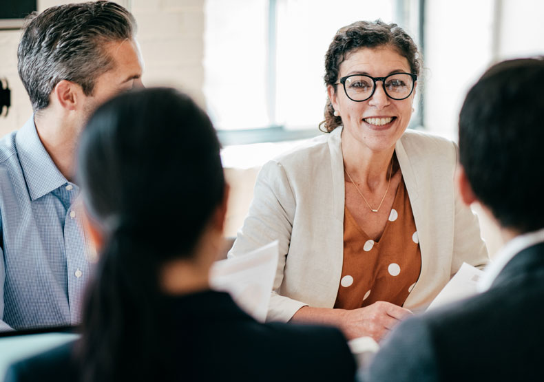 woman meeting at table with other professionals