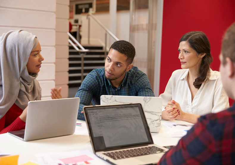 Diverse group sitting around table talking