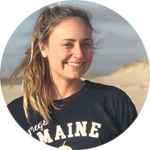 Portrait photo of smiling woman with blond hair and beach scene in the background