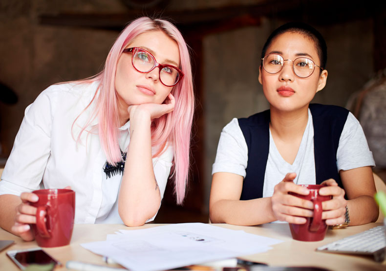 two young females with coffee mugs