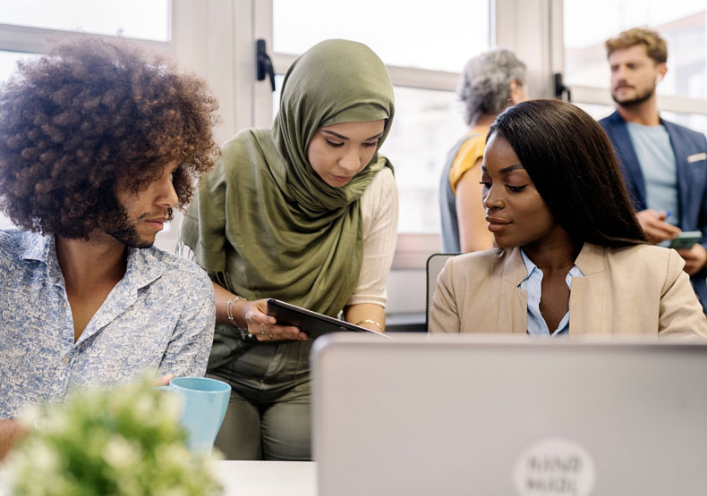 three diverse adults meeting at table