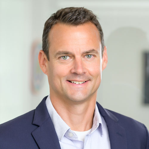 Portrait photo of white man in with shirt and navy jacket