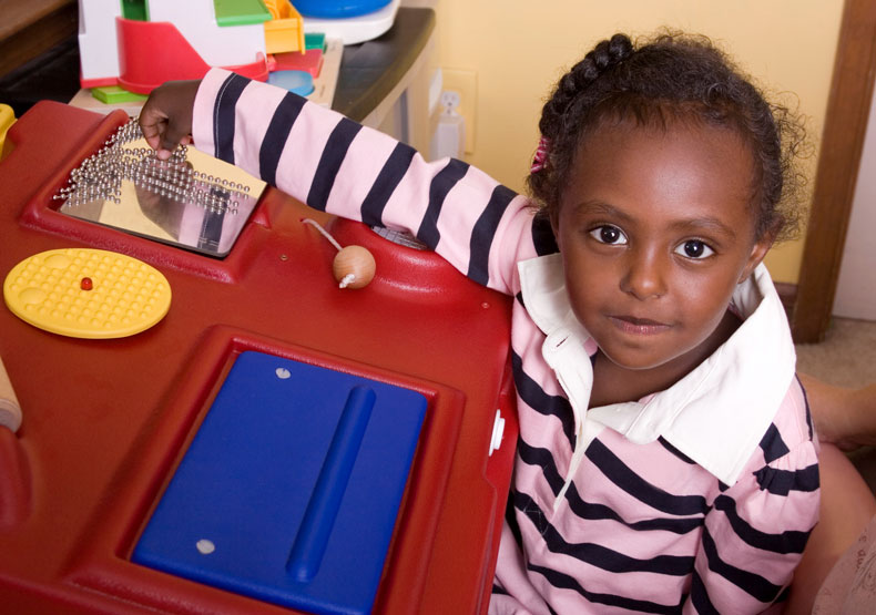 child at desk with blocks