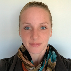 Portrait photo of woman with hair pulled back and colorful scarf around neck