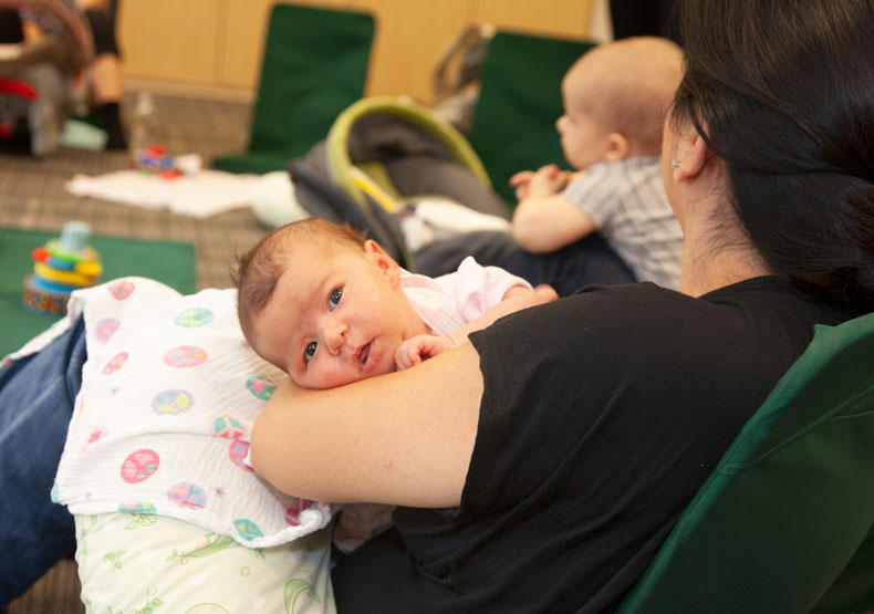 Mother holding new baby in group support class