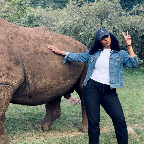 woman standing next to rhino