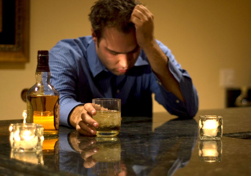 photo of a man at a bar with head in hands