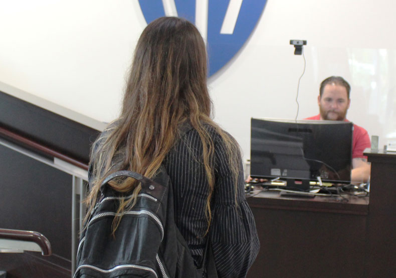 Student with backpack at front desk