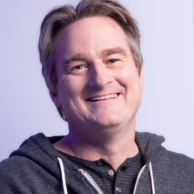 Close up photo of smiling man in gray top