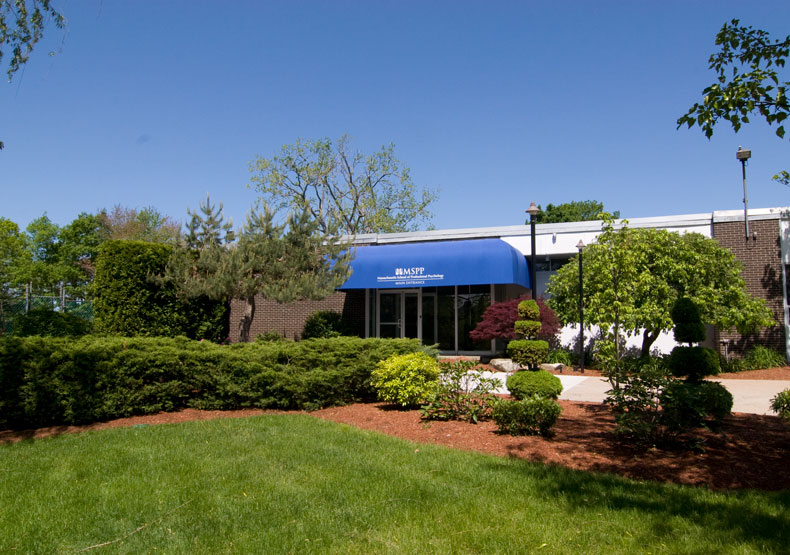 photo of building with blue awning and green grass in front