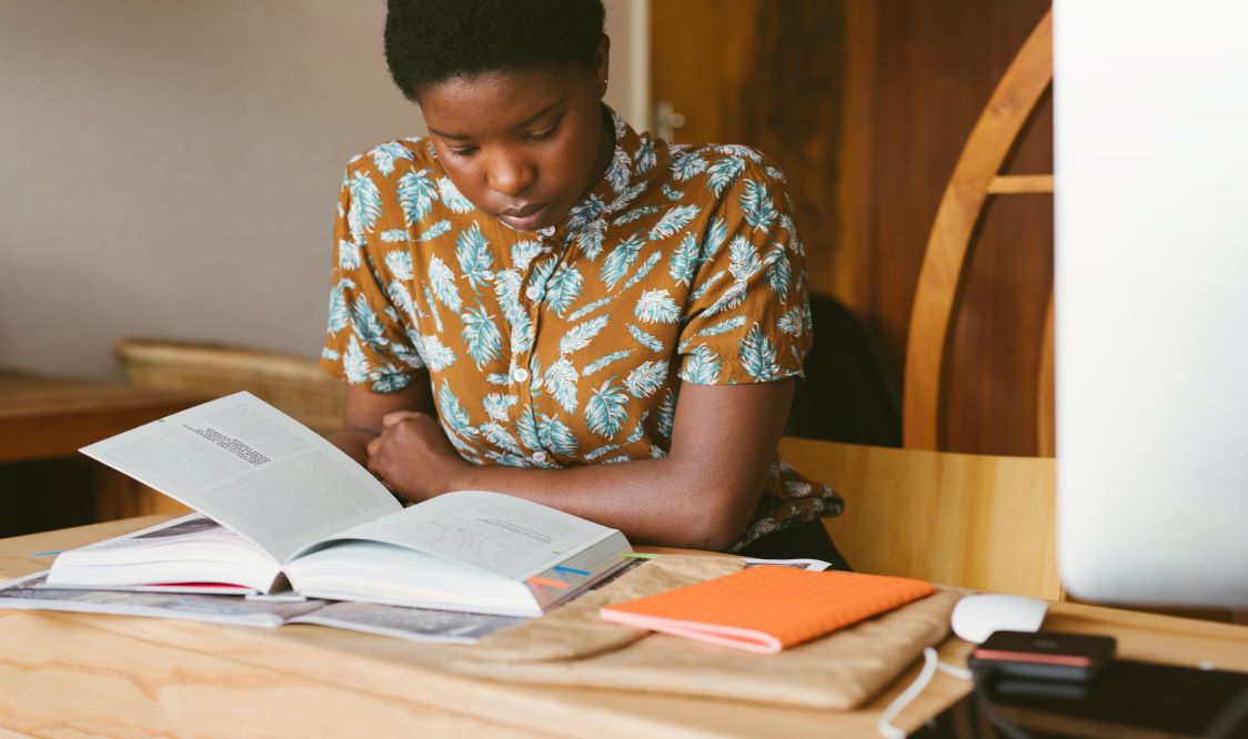 Photo of person reading a textbook 