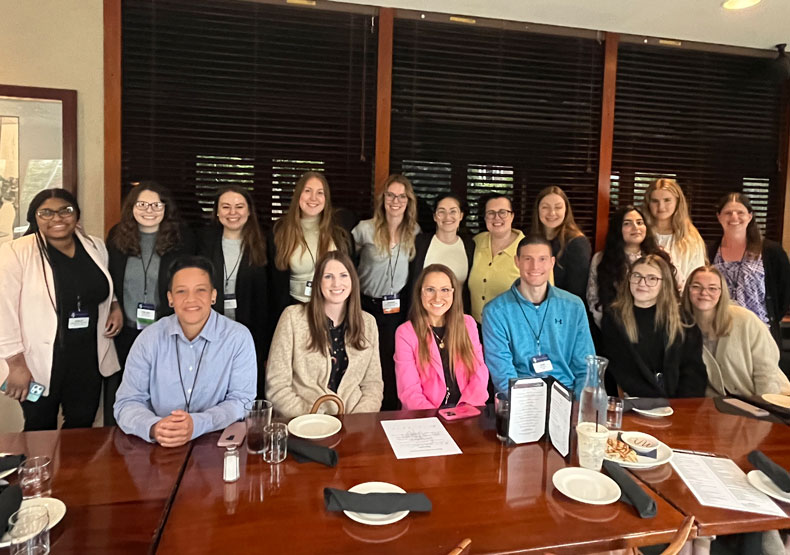 group of people sitting and standing in front of a table