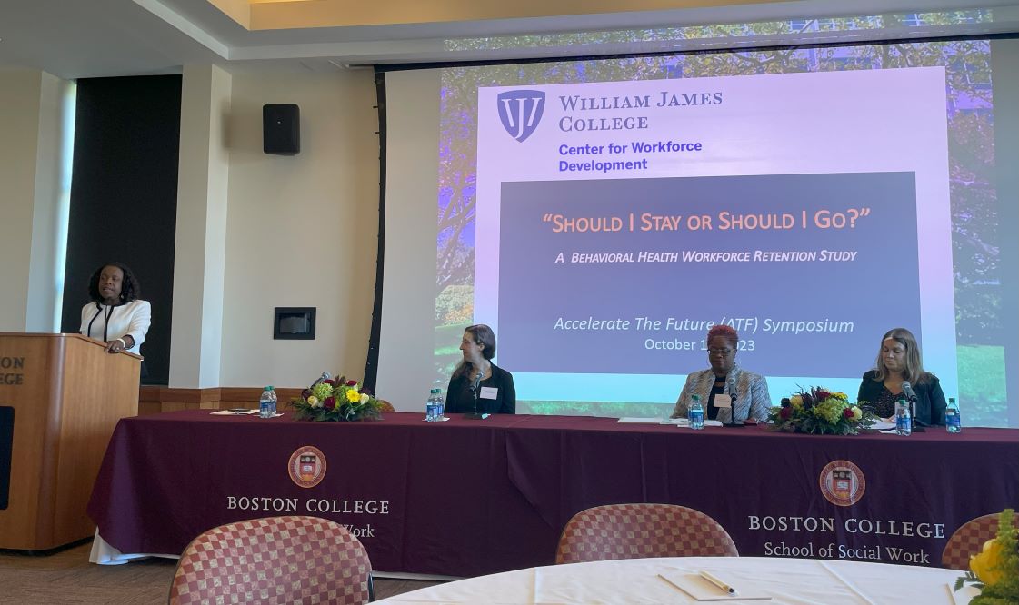 Photo of four people presenting a slide titled, "Should I Stay or Should I Go"