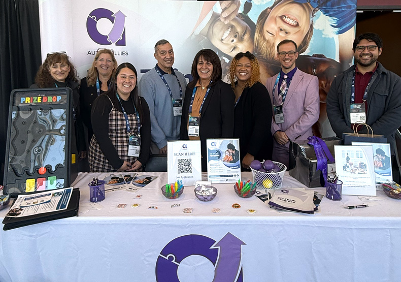group of people standing behind a table