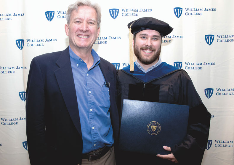 Father with son in cap and gown holding diploma