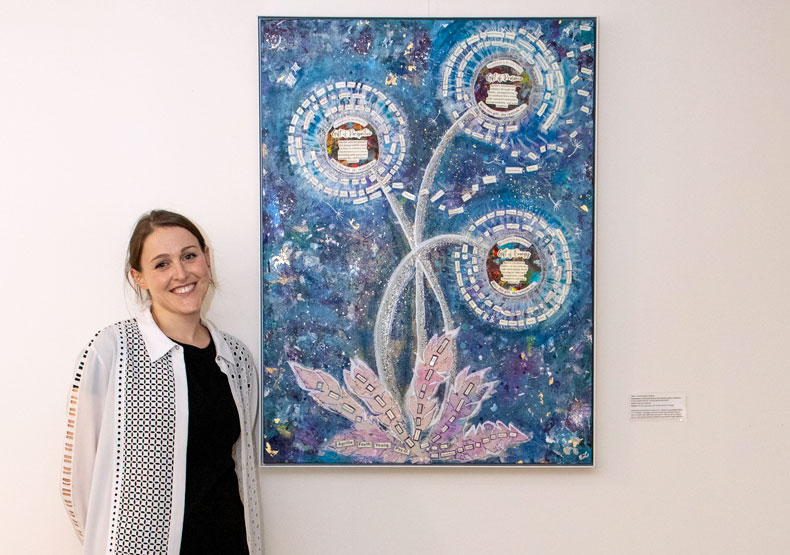 woman standing in front of an art exhibit