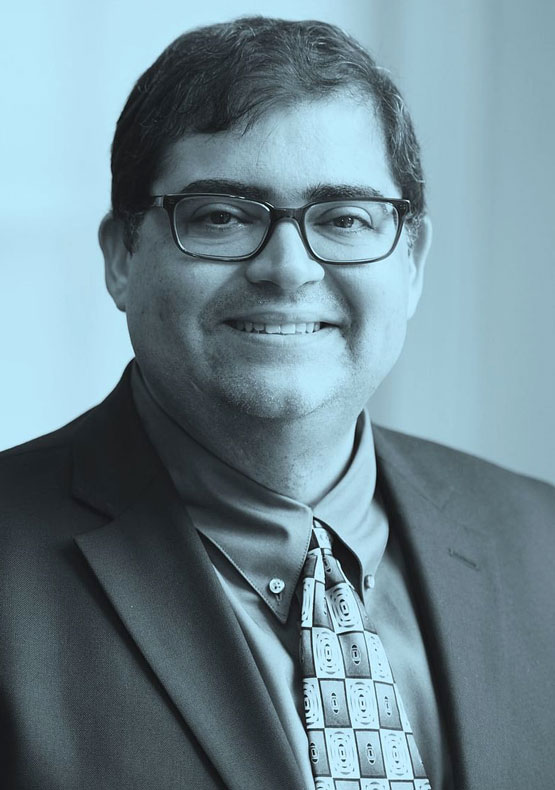 black and light blue duotone portrait of gentleman wearing glasses and smiling