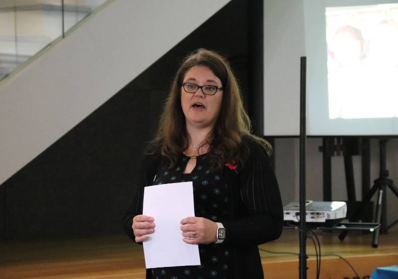 Jenny D'Olympia speaks in front of a crowd