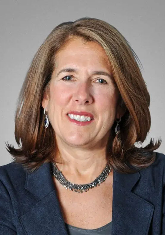 Profile photo of smiling woman in blue jacket and neutral background