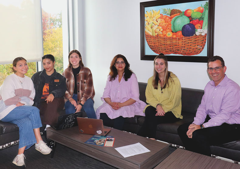 photo of group of adults sitting on a couch and smiling at the camera