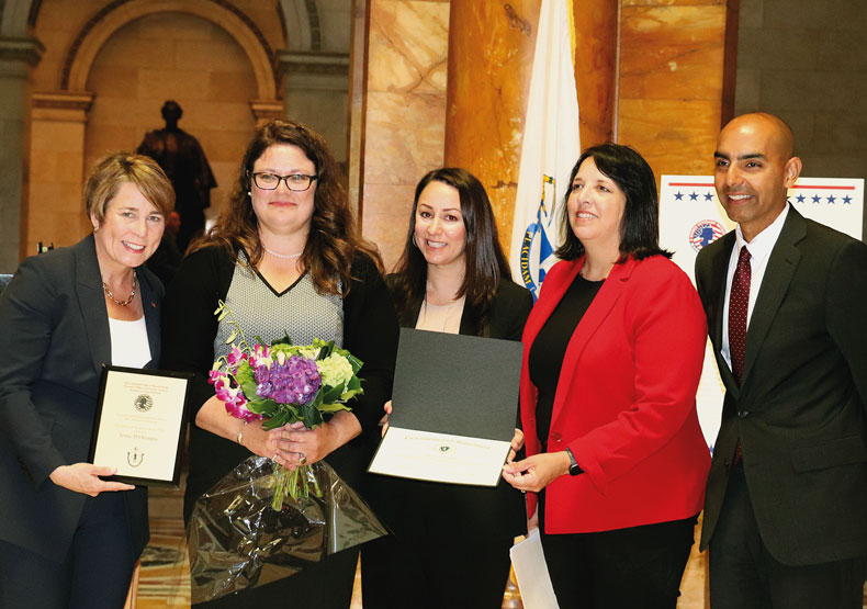 group of distinguished adults at statehouse holding award