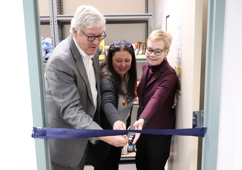 three people cutting ribbon at food pantry