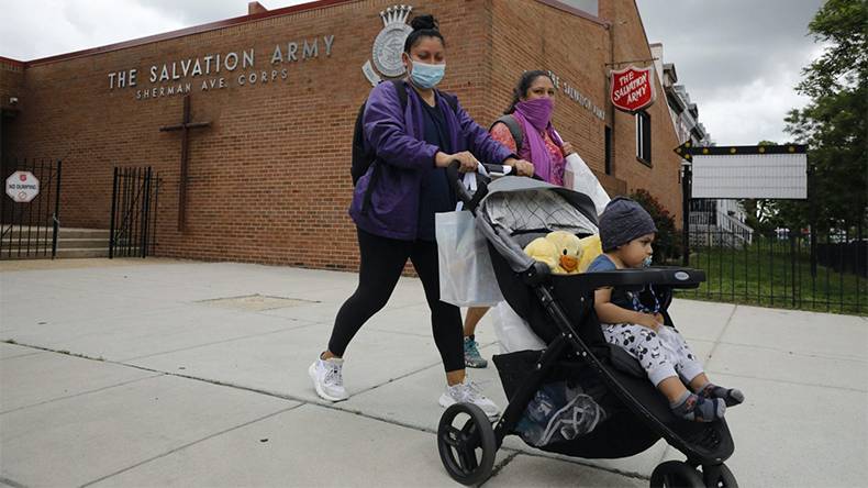 Two women push a child in a stroller