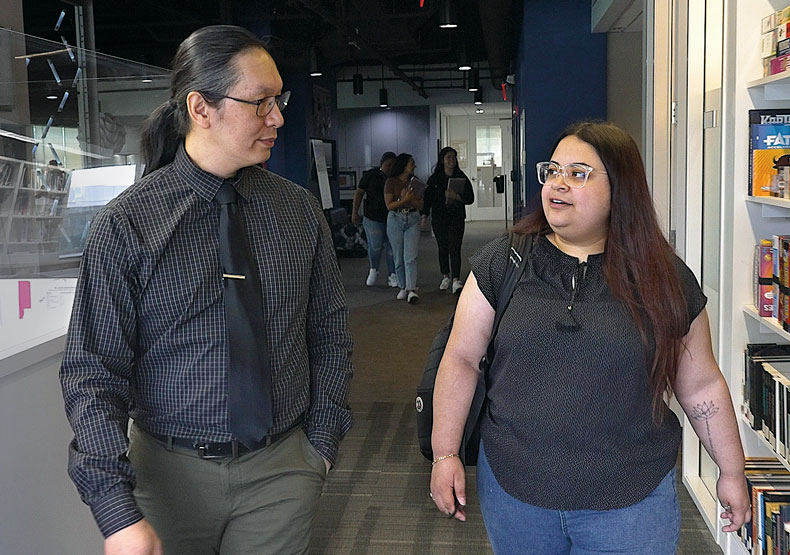 Dr. Ronald Lee and Vanessa Benitez Cisneros talking and walking in school hallway