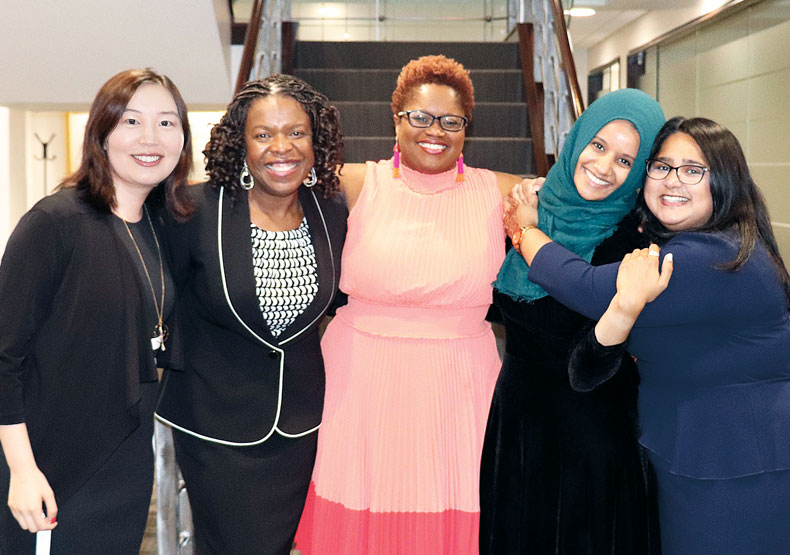 group of five women with arms around each other