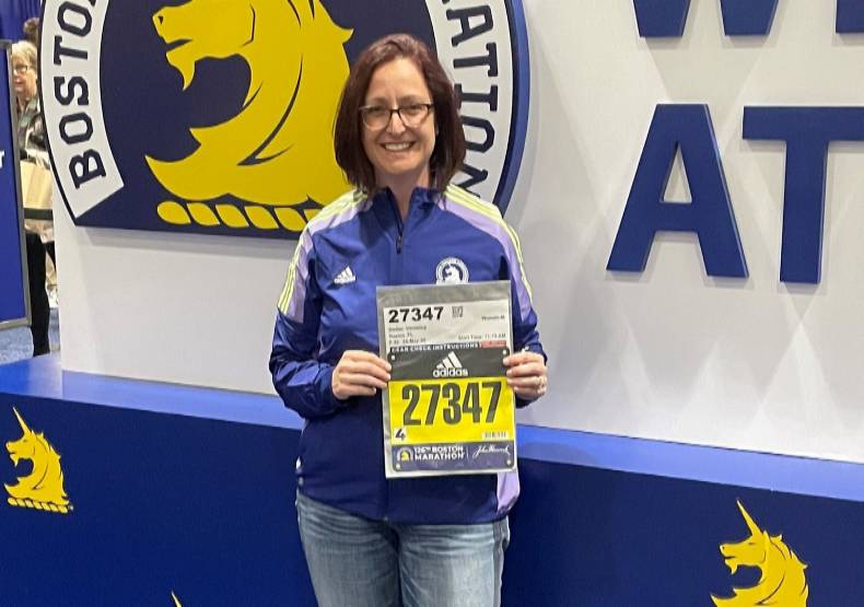 Dr. Veronica Steller holding her bib number prior to the 2022 Boston Marathon.