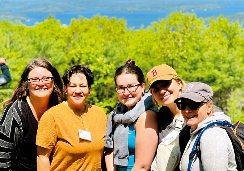 group of woman smiling in front of expansive landscape