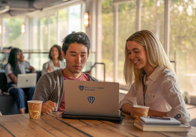 students in lounge on laptop